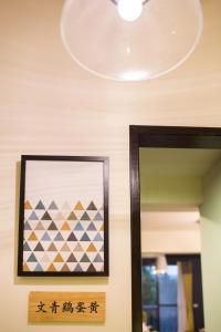 a mirror in a room with a picture and a chandelier at Salmon B&B in Hualien City