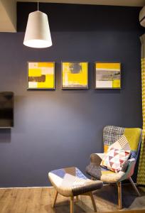 a living room with a chair and pictures on the wall at Salmon B&B in Hualien City