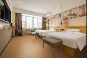 ein Hotelzimmer mit 4 Betten und einem TV in der Unterkunft City Comfort Inn Fangchenggang Government Affairs Center in Fangchenggang