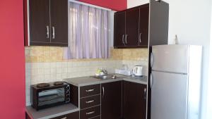 a kitchen with black cabinets and a white refrigerator at Apartments Neri in Ksamil