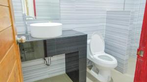 a bathroom with a white toilet and a sink at Studio in townhouse with private bath room and kitchenette in Amphoe Phra Khanong