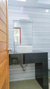 a bathroom with a sink and a mirror at Studio in townhouse with private bath room and kitchenette in Amphoe Phra Khanong