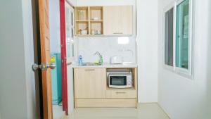 a small kitchen with a sink and a microwave at Studio in townhouse with private bath room and kitchenette in Amphoe Phra Khanong