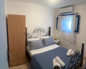 a bedroom with a bed with blue and white sheets at Aosa seaside home in Áyios Stéfanos