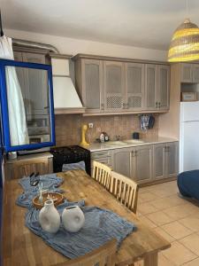 a kitchen with a wooden table with a blue table cloth at Aosa seaside home in Áyios Stéfanos