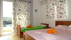 a bedroom with two beds and a large window at Apartments Neri in Ksamil +76 photos