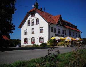 un gran edificio blanco con techo rojo en Hotel Gasthof zum Neubau en Kißlegg