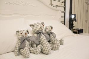 three teddy bears sitting on top of a bed at Salmon B&B in Hualien City