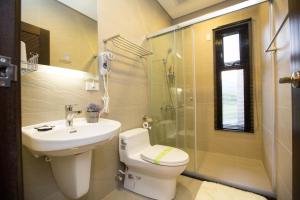a bathroom with a toilet and a sink and a shower at Salmon B&B in Hualien City