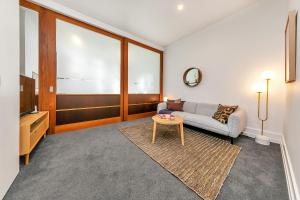 ein Wohnzimmer mit Couch und Tisch in der Unterkunft Stylish Retreat with city views in Auckland CBD in Auckland + 32 Fotos