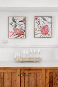 un comptoir avec des verres à vin dessus avec trois images dans l'établissement Charming 1930s Cottage Retreat I Pet Friendly Escape, à Geelong West