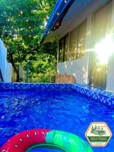 a swimming pool in front of a house at Villa Thalia Staycation hub in Cogeo Village