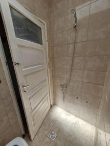 y baño con ducha, puerta y aseo. en Habitación de Casa en Av San Martin 422, en Santa Rosa