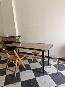 una mesa y dos sillas sentadas en un suelo a cuadros en Habitación de Casa en Av San Martin 422, en Santa Rosa