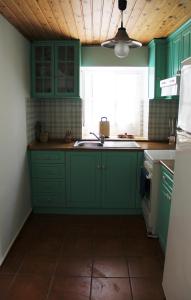 a green kitchen with green cabinets and a window at Chios Stone House in Chios