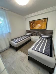 two beds in a room with a painting on the wall at Ruhige geräumige Wohnung in Pforzheim