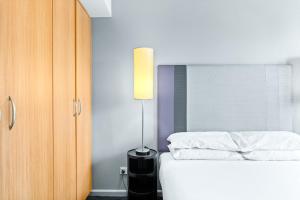 Un pat sau paturi într-o cameră la Sleek 1-Bed by Jubilee Park with Pool +4 fotografii