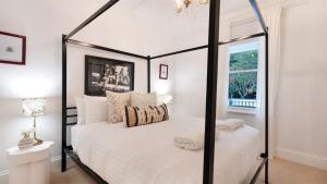 a bedroom with a black and white canopy bed at Glenbrae in Bundanoon