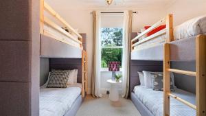 two bunk beds in a room with a window at Glenbrae in Bundanoon