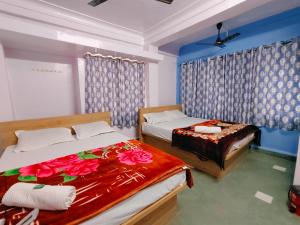 two beds in a room with blue walls at Mangallam Guest House in Pune