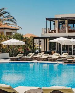 a swimming pool with chairs and umbrellas next to a building at Sea Breeze Baku in Baku