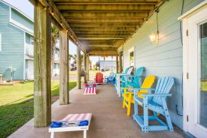 a covered porch with colorful chairs and tables at Coastal Casa in Port Aransas