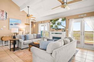a living room with two couches and a fireplace at Coastal Casa in Port Aransas