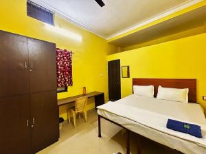 a small bedroom with a bed and a desk at Hotel saanvi inn in Raipur