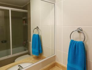 a bathroom with blue towels hanging on a mirror at Alquiler de departameto viña del mar in Viña del Mar +8 photos