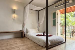 a bedroom with a bed and a large window at Sabaidee Chiangmai Hotel in Chiang Mai