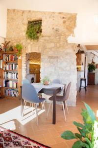 a table and chairs in a room with a stone wall at Casa artística i acollidora a Pau in Pau
