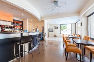 a bar in a restaurant with tables and chairs at Hotel Apollo in Cesenatico