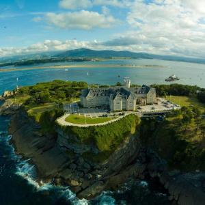 a building on a cliff next to the ocean at Hostel Santander in Santander