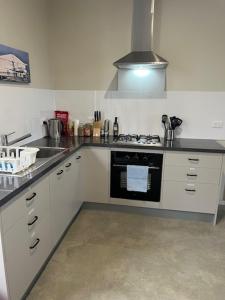 a kitchen with a sink and a stove top oven at Runway 27 Getaway - Private Room and Ensuite With Shared Kitchen and Dining in Temora