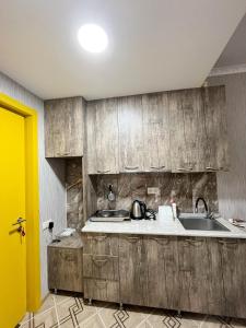 a kitchen with wooden cabinets and a sink at Bakuriani MIX 401G in Bakuriani