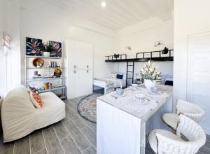 Boutique Studio in Laoag City في Sagneb: غرفة معيشة مع طاولة وكراسي بيضاء +22 صورة