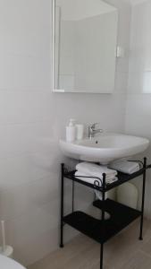 a white bathroom with a sink and a mirror at Holiday Home Shangri-La in Milna +67 photos