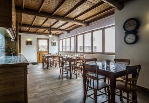 a dining room with tables and chairs and a clock on the wall at Casa do Campo de São Francisco in Ponta Delgada