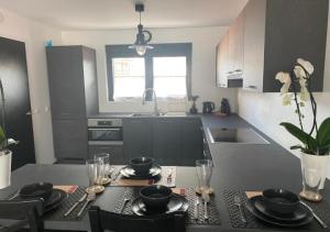 a kitchen with a table with plates and glasses on it at Homeawayfromhomeghent with private parking in Ghent