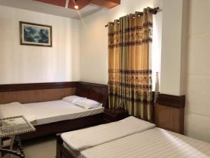 a room with two beds and a window at Hong Dao Hotel. in Can Tho