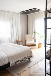 a bedroom with a bed and a chair at Doria Luxury Boutique Hotel in Dishon