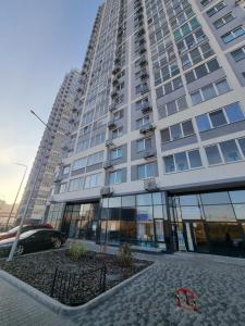 a tall building with a car parked in front of it at Your Flat Lebedinny in Kyiv