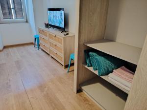 a room with a tv on a dresser and a bedroom at lucia haus trieste in Trieste +11 photos