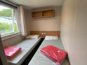 due letti in una piccola stanza con una finestra di Camping siblu - 8pers - 100m des plages a Canet-en-Roussillon