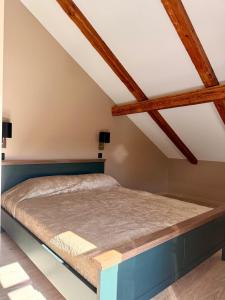 a bed in a room with wooden beams at Atpūta Grašos Mazirbe in Mazirbe