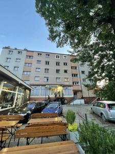 una fila di panche di legno di fronte a un edificio di Bugenwilla Apartament a Sopot