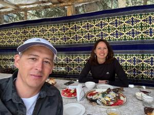 a man and a woman sitting at a table with food at Helena guest house in Cholpon-Ata