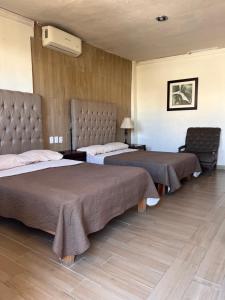 a room with two beds and a chair in it at Eco-Hotel in Mazatlán