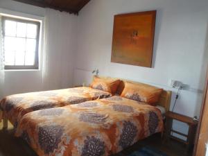 1 dormitorio con 2 camas y una foto en la pared en Casas Erel en Puntagorda