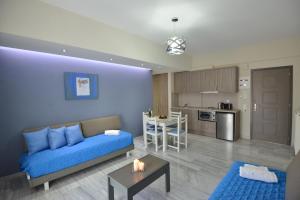 a living room with a blue couch and a kitchen at Vesperi Studios & Apartments in Rethymno